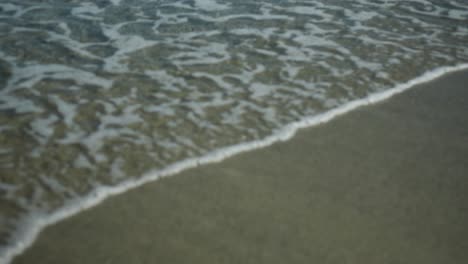 Agua-Del-Océano-Rompiendo-Contra-La-Playa-De-Arena,-Plano-Medio