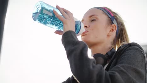 Vista-Inclinada-Hacia-Arriba-De-Una-Mujer-Tomando-Un-Sorbo-De-Agua.