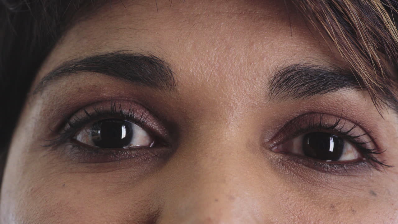 cerrar los ojos de una mujer hermosa que se abre con maquillaje mirando a la cámara belleza cosméticos macro