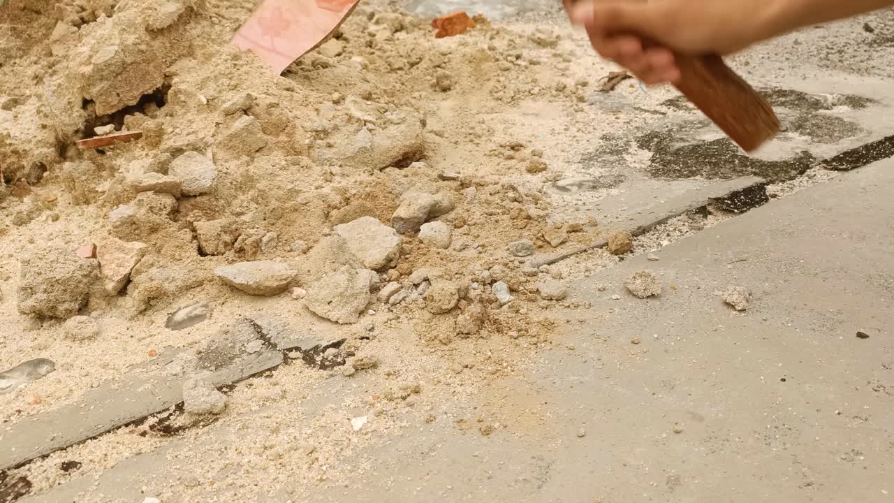 cerca de la piedra arenisca rompiendo la mano con el martillo