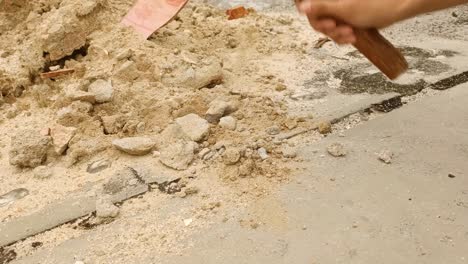 cerca de la piedra arenisca rompiendo la mano con el martillo