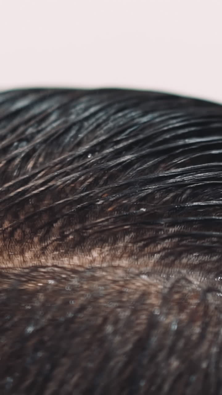 Skilled hairstylist combs wet hair of man client at cutting in salon extreme closeup slow motion. Professional beauty and style service providing
