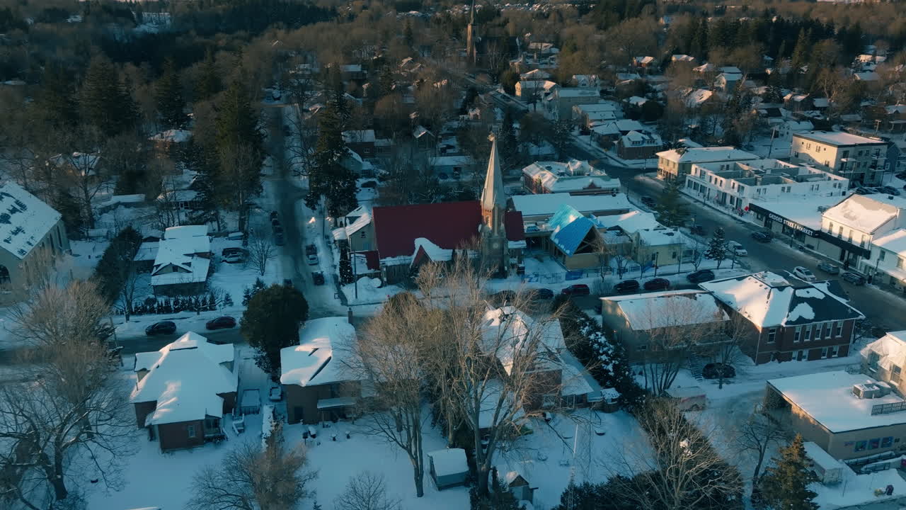 Vista aérea da Igreja de São João coberta de neve na cidade de Elora, Ontário, cena de inverno serena.