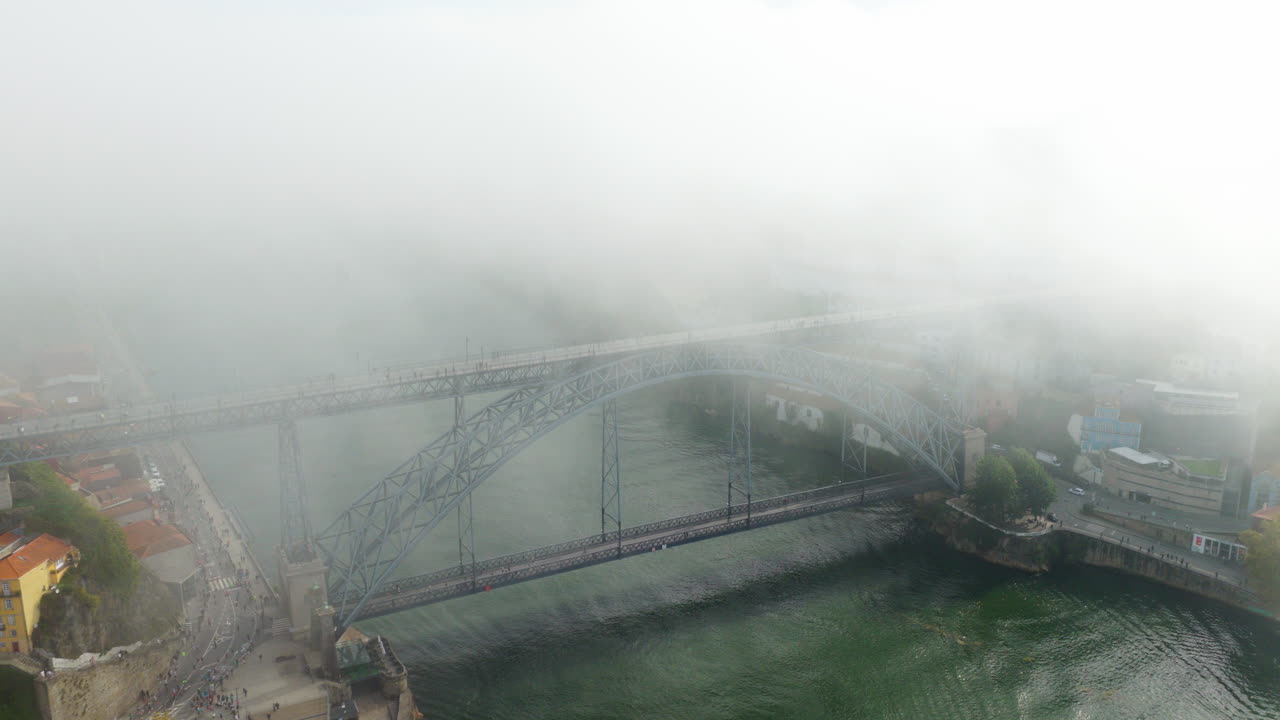 Foggy Clouds Engulfing Luís I Bridge Spanning The Douro River In Porto, Portugal. Aerial Drone Shot