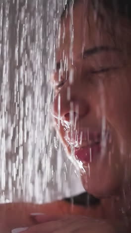 happy woman enjoys water sprays in shower closeup. satisfied lady smiles standing in hot clear flow in bathroom. recreation during bathing time