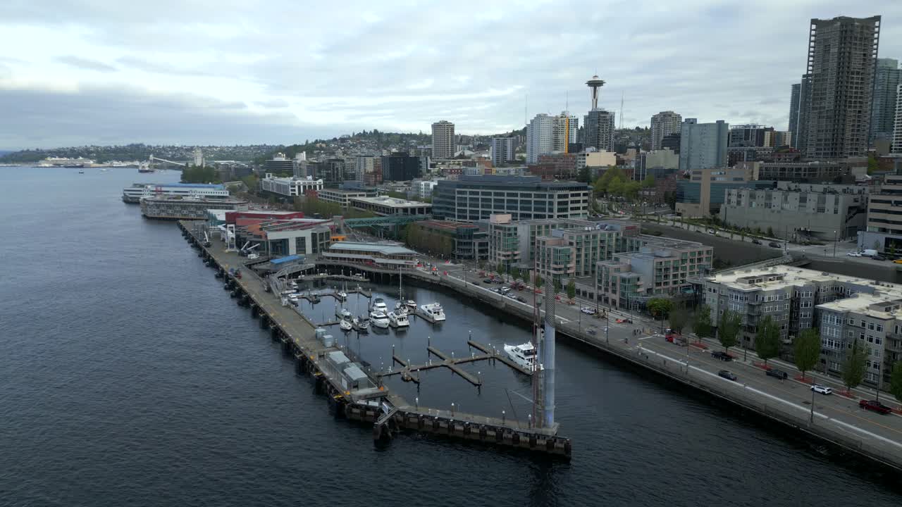 Panoramic aerial view of Pier 66 boat terminal by calm, coastal waters and Seattle Waterfront cityscape backdrop at Washington, USA.