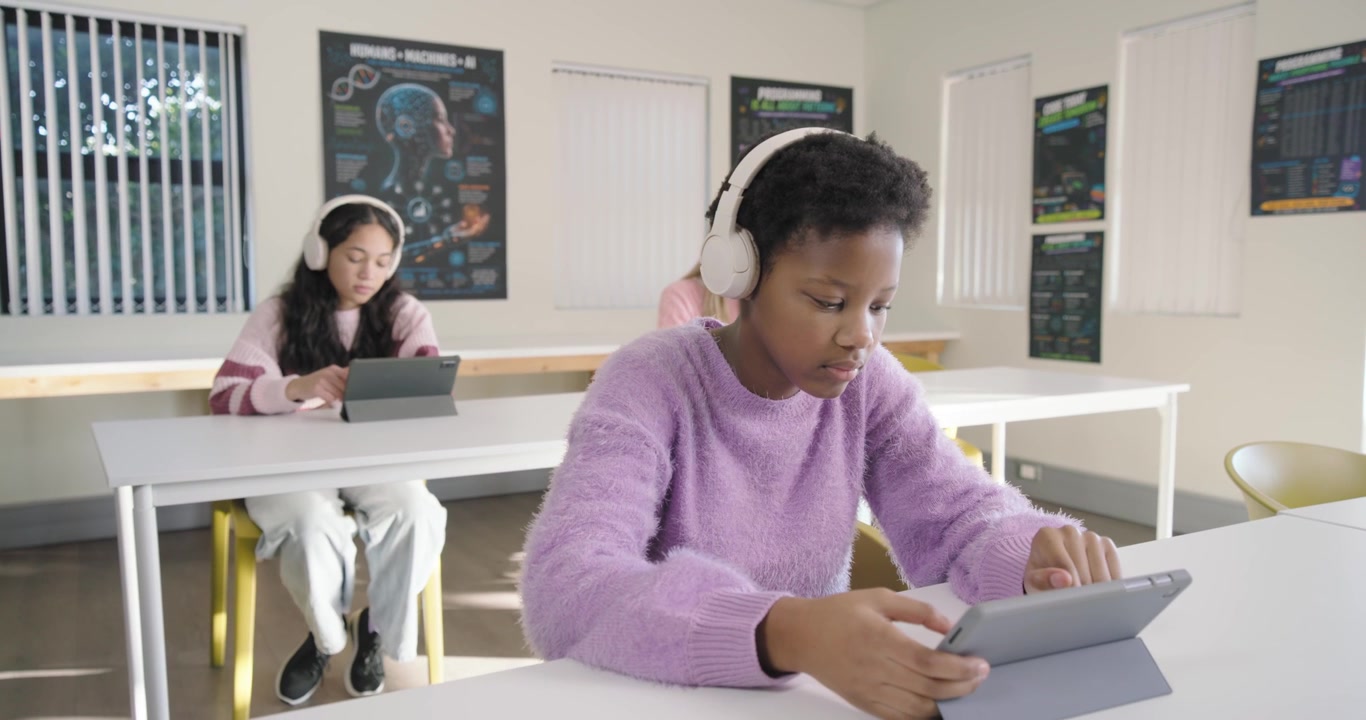 Adolescentes diversas reagindo a uma deixa da aula, com uma adolescente afro-americana mexendo no tablet para a aula.