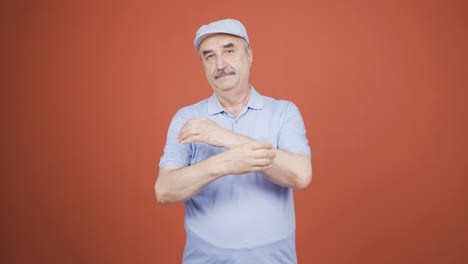 un anciano mirando a la cámara haciendo una señal de confianza.