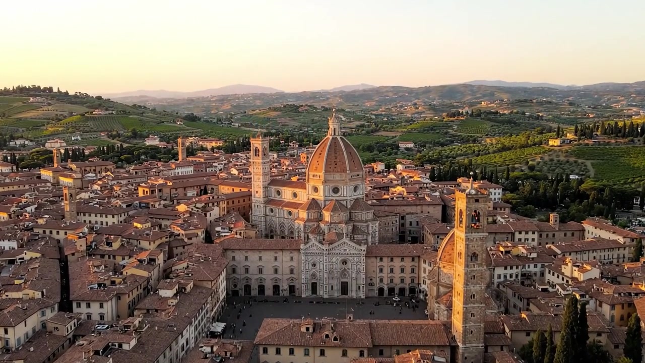 Vedute aeree di una storica città italiana al tramonto, che mettono in risalto un'architettura mozzafiato e paesaggi pittoreschi nella morbida luce dorata.