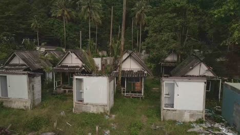 aerial birds eye view reveal shot of a abandoned and derelict beach bungalow tourist resort in koh chang thailand due to the effect of covid on global travel and tourism