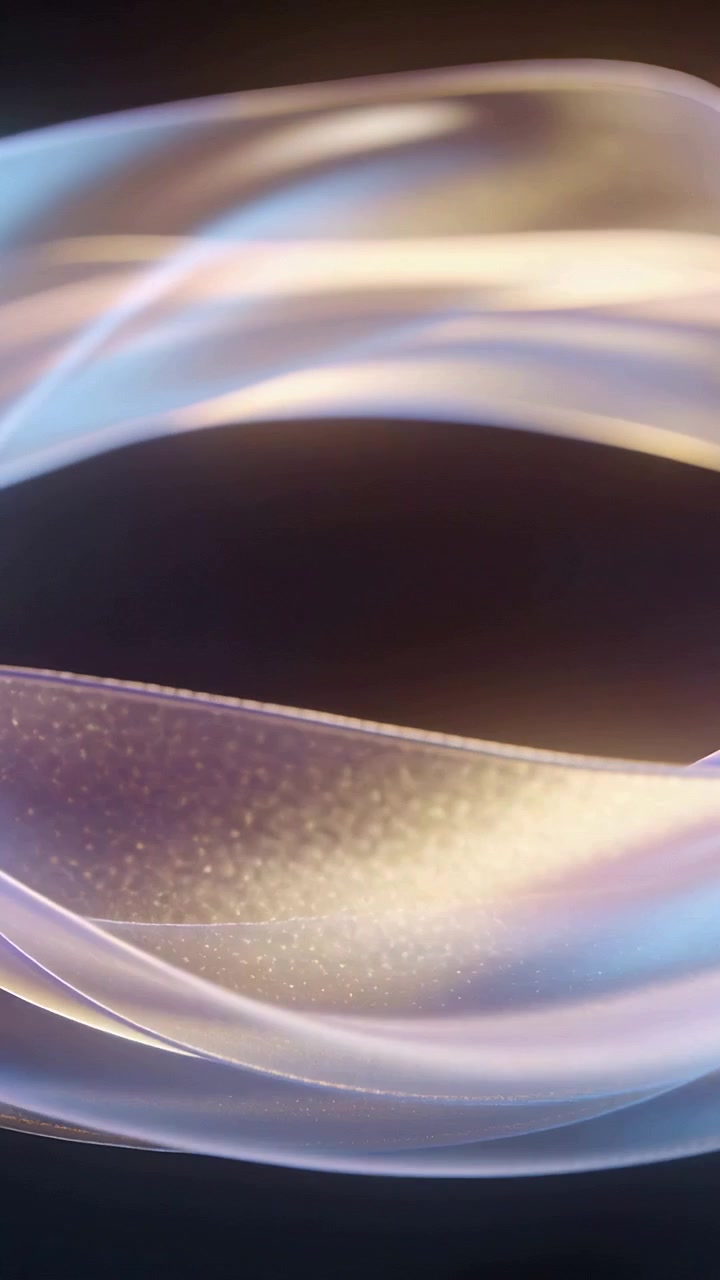 Vertical video: Shifting light moving two sheer ribbons across dark studio, revealing fine sparkles