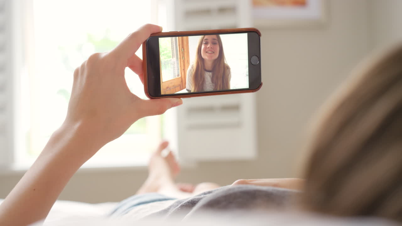 mujer haciendo una llamada de video en la cama