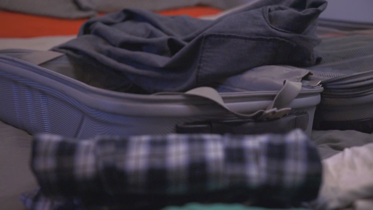 Man Packing Clothes On The Small Suitcase. Business Travel. - Close Up shot