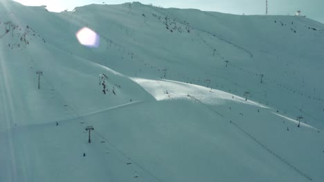 beautiful snowy ski slopes and chairlifts on ski resort mountain, aerial view