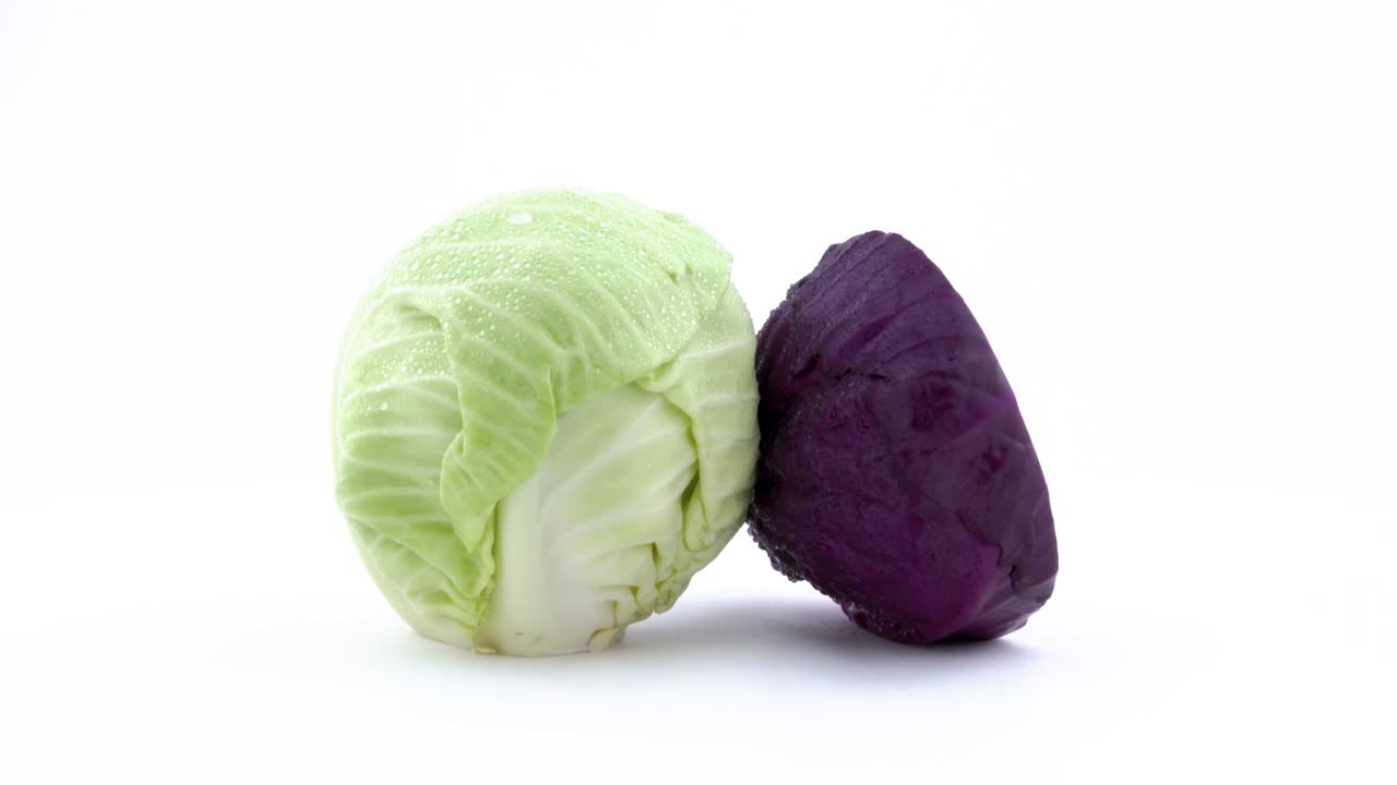 un mini repollo blanco entero y una mitad o repollo rojo. girando en la mesa giratoria aislado en el fondo blanco. primer plano. macro.