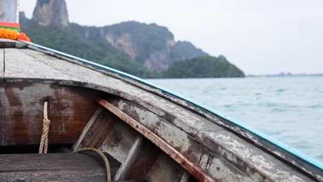 wooden boat sailing near krabi's scenic mountains