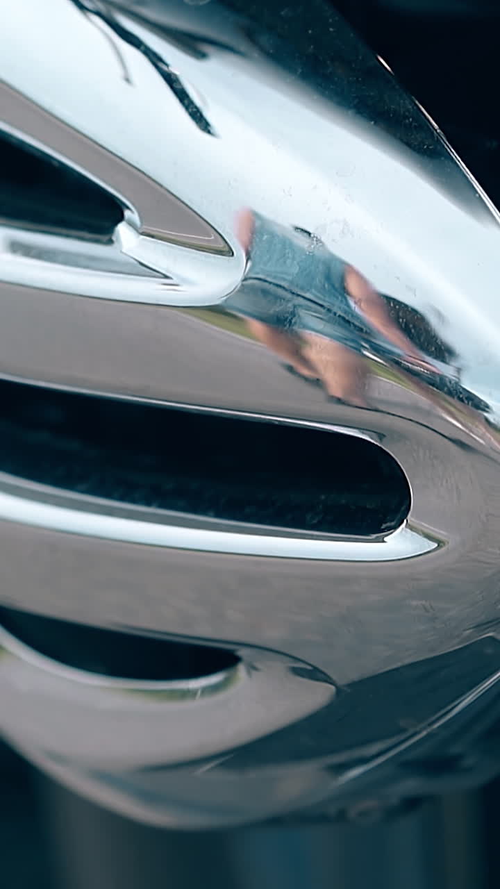 close view modern silver shining motorcycle detail reflects walking couple in denim clothes