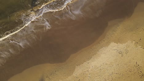 young surfer boy coming out of water, la pedrera beach in uruguay