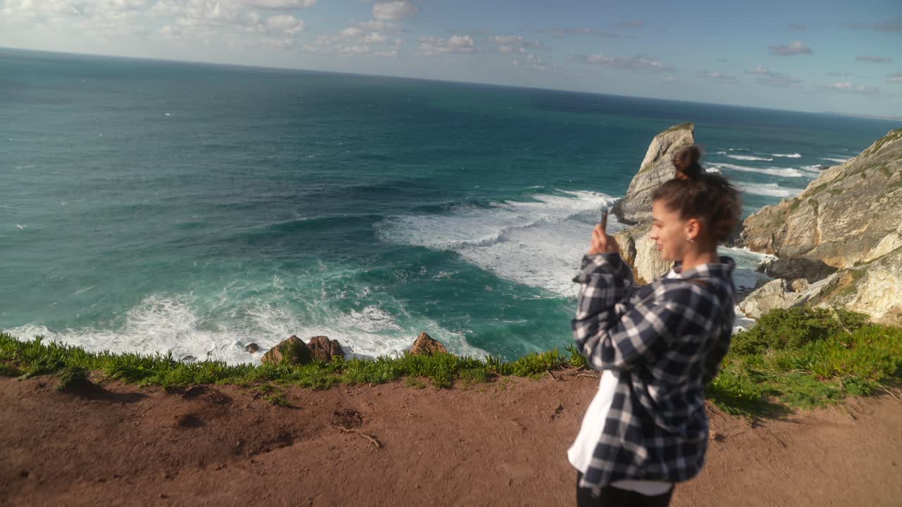 Woman taking photo of coastal scenery