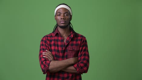 young handsome african man with dreadlocks against green background