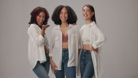 three happy women friends posing together in studio