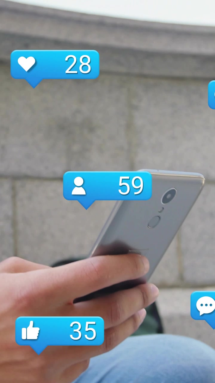 Vertical video: Man sitting on step tapping phone, making blue social bubbles with followers rising