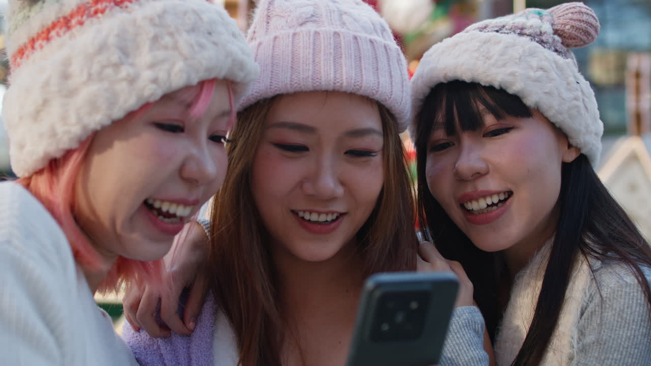 Three friends looking at a cell phone