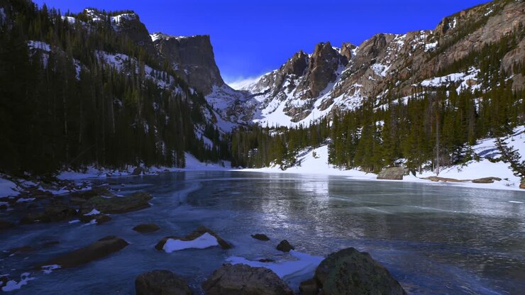 Lago Dream Colorado, Parco Nazionale delle Montagne Rocciose, Lago Emerald, Estes Park, Lago Bear, sentiero escursionistico, Parco Nazionale delle Montagne Rocciose, cielo azzurro e soleggiato, Hallett Peak, Flattop, neve che soffia, ventoso, ghiaccio blu ghiacciato, rocce in ombra, zoom indietro
