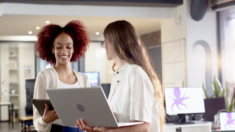 Collaborating in office, women using laptop and tablet for creative writing business