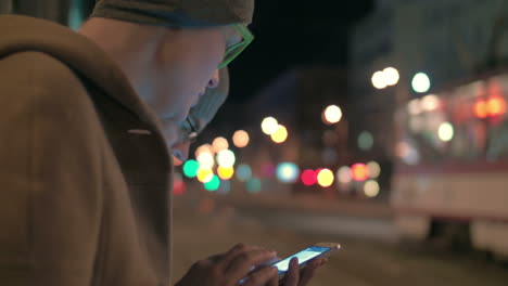 mujer escribiendo en su teléfono inteligente en la parada de autobús