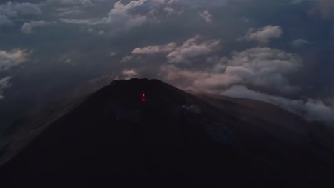 Cinematic-aerial-view-into-Fuego-volcano's-lava-filled-crater-at-blue-hour,-Guatemala