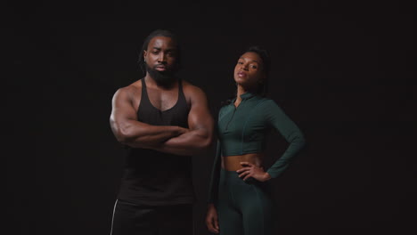 Studio-Portrait-Of-Determined-Male-And-Female-Athletes-Training-In-Fitness-Clothing-Shot-Against-Black-Background-2