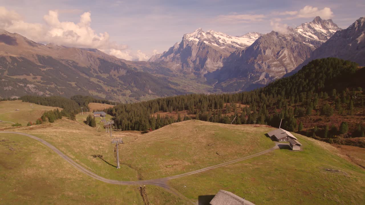 imágenes aéreas de drones empujando sobre prados alpinos y cabañas alpinas en grindelwald, suiza