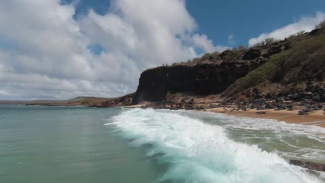 Aerial-footage-from-FPV-racing-drone-of-a-sun-lit-green-ocean-during-a-summer-sunny-day-in-Hawaii