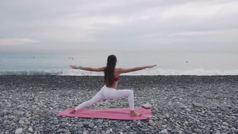 woman practicing yoga on a beach