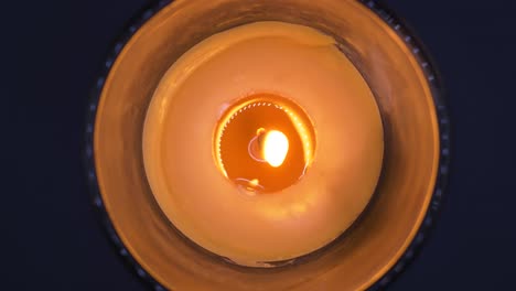 overhead shot of burning scented candle rotating against black background