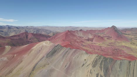 drone glides forward, showcasing rainbow mountain in the enchanting background of red valley, peru