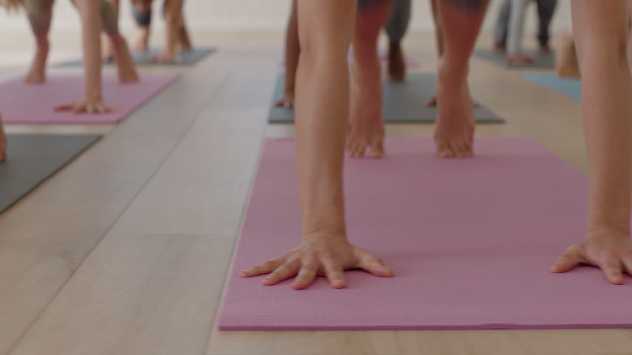 un grupo cercano de mujeres en clase de yoga practicando pose de perro boca abajo entrenando un estilo de vida saludable haciendo ejercicio disfrutando de la meditación en el gimnasio