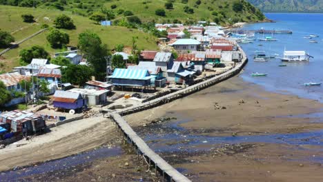 Traditional-phinisi-boats-moored-off-a-coastal-Indonesian-Village-at-low-tide