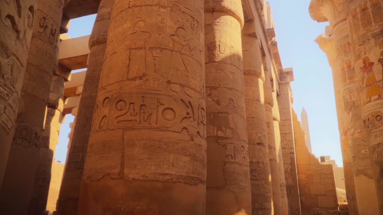 Close up of detailed carved pillars with hieroglyphs in the Hypostyle Hall, Luxor Egypt. 
Soft warm light and a small tilt down camera movement.