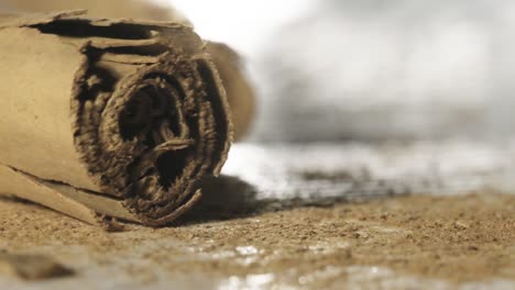 macro shot of cinnamom stick falls on table surface covered in cinnamom powder, super slow motion