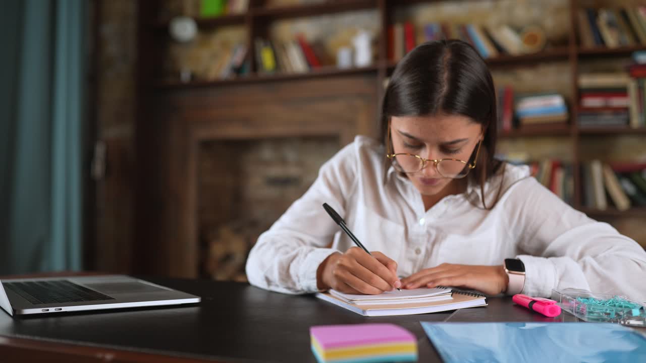 mujer joven estudiando en un escritorio en un entorno de biblioteca