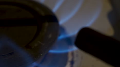 macro shot of a gas burner on a stove, trucking left