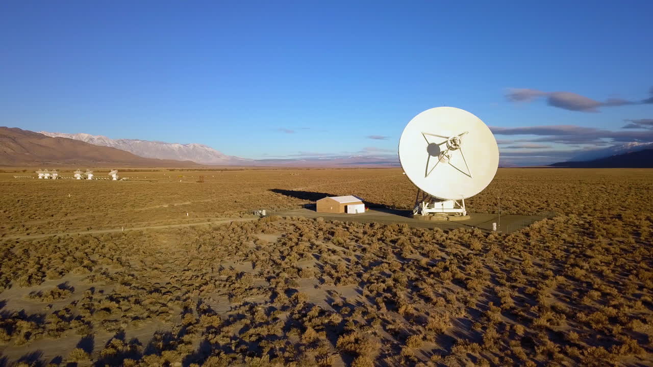 Aerial view looking around a space station area, with a large and small arrays - pan, drone shot