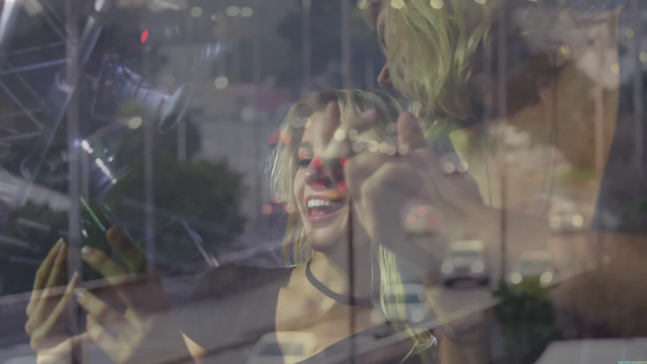 Two marketers using smartphone selfie technology in club with bokeh lights and city traffic overlay