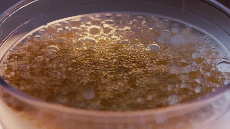 Primo piano di una superficie liquida dorata con numerose bolle