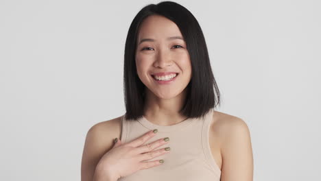 asian woman laughing in front of the camera.