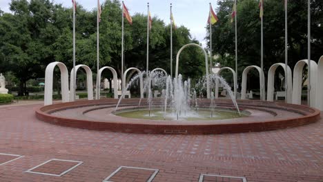 Spanish-Park-Plaza-water-fountain-in-Mobile,-Alabama-with-gimbal-video-walking-forward-close-up-in-slow-motion