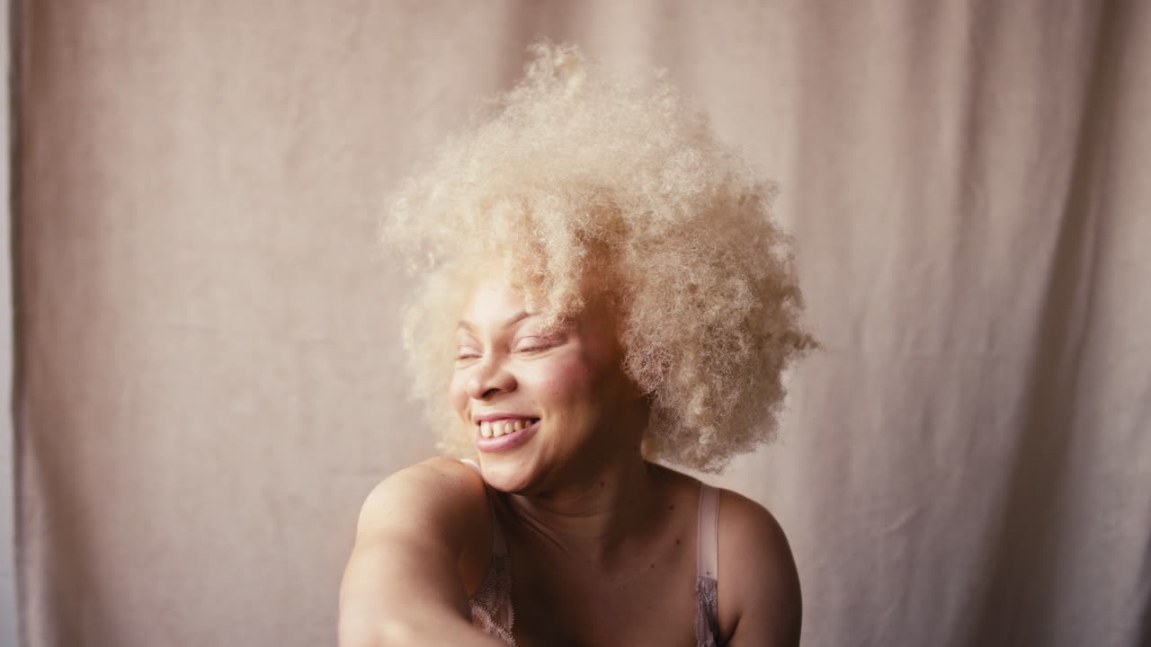 자신감 넘치는 자연스러운 알비노 여성의 스튜디오 초상화 촬영은 몸의 긍정성을 촉진하는 속옷을 입고 있습니다.