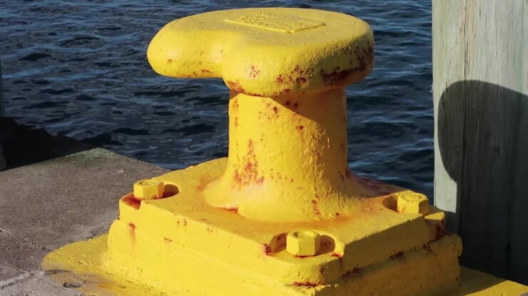 Una bitta gialla in un vecchio porto marittimo.